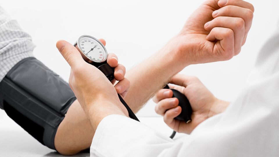 Arzt misst den Blutdruck eines Patienten