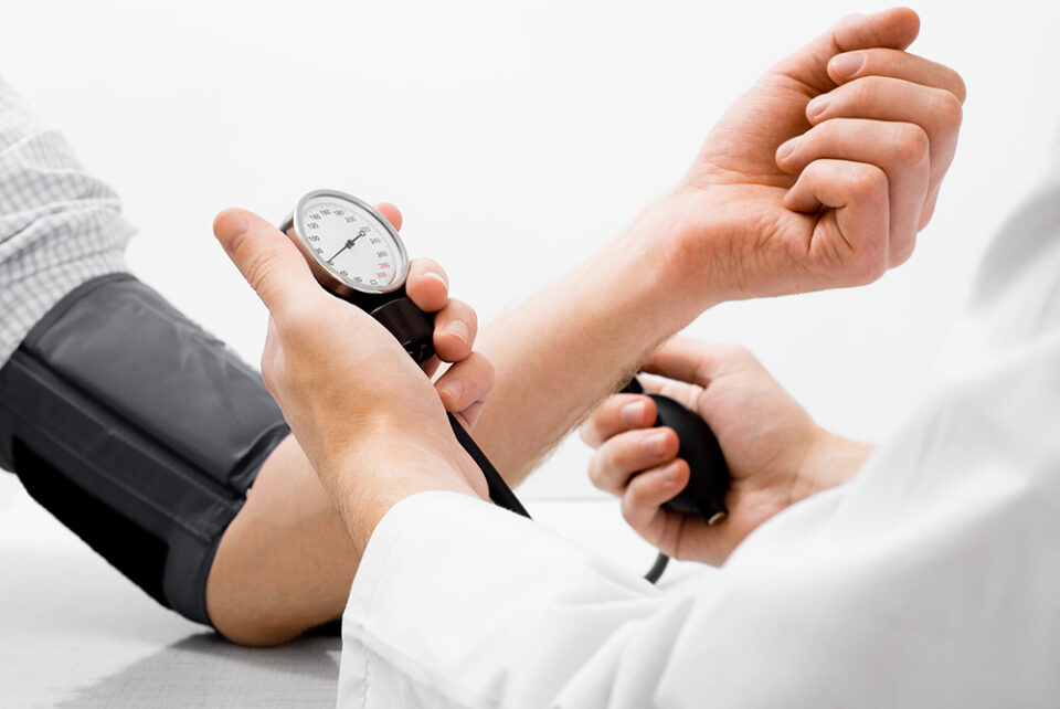 Arzt misst den Blutdruck eines Patienten